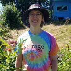 person in hat wearing tie-dye T-shirt with the words St. Rage truth. justice. rock & roll